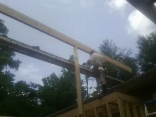 Carpenter setting a ridge beam over a new addition frame — Ice Dam Removal by Roofing Brothers in Galvin