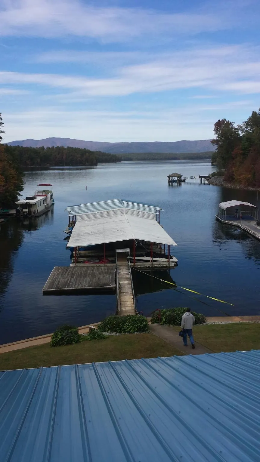 View across a lake from a newly installed blue metal roof in Galvin