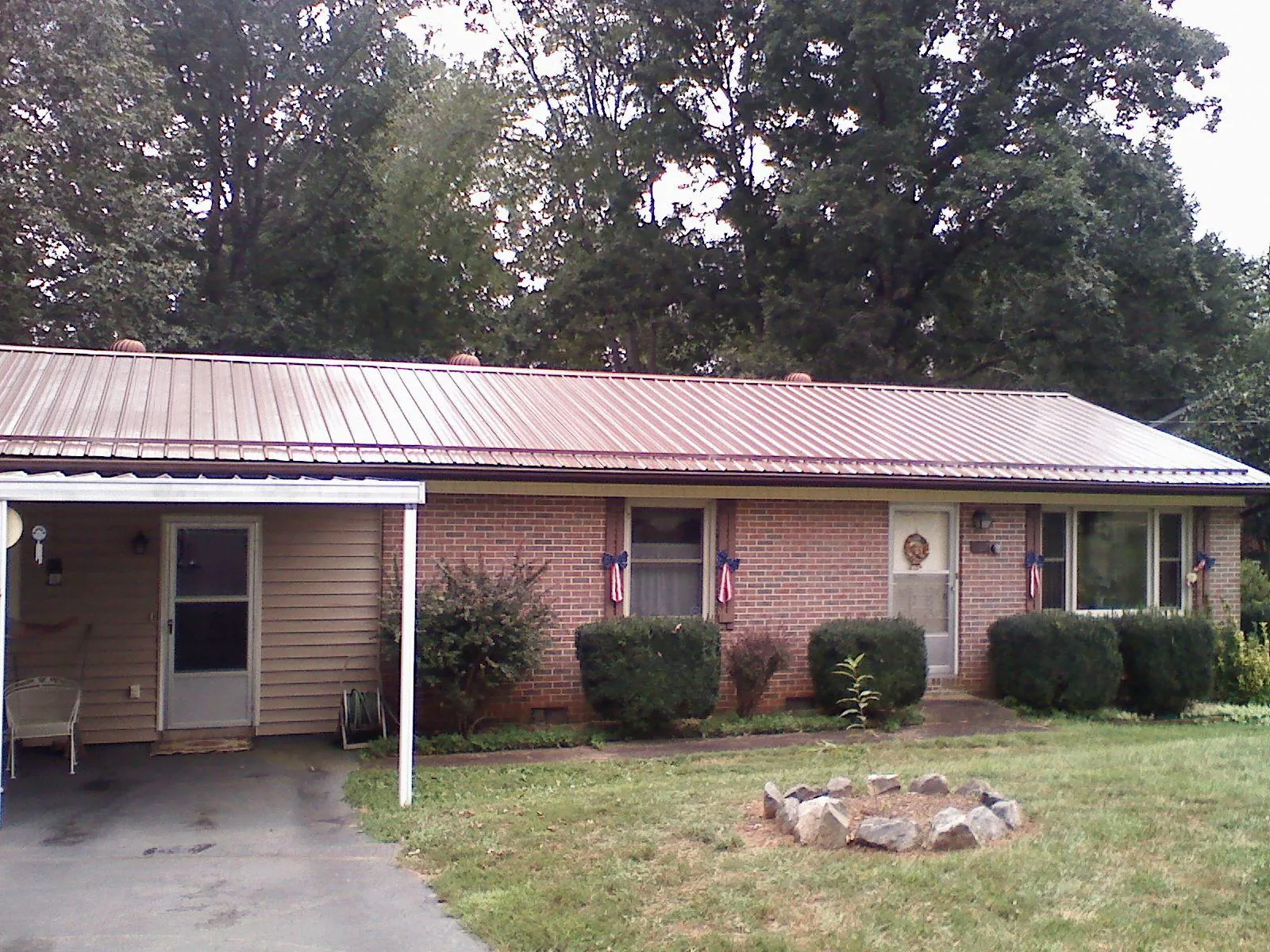 Bronze metal roof and carport on a brick ranch home — Roof Repair work by our crew in Galvin