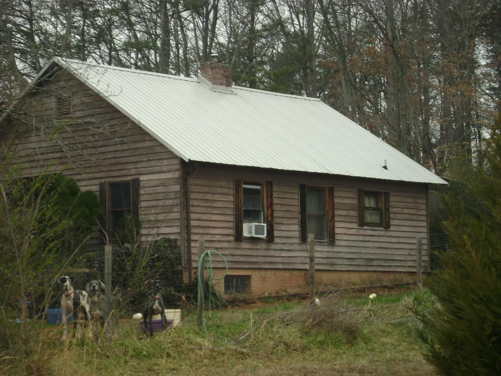 White metal roof on an old wood sided farmhouse, from a Metal Roof Installation job in Galvin